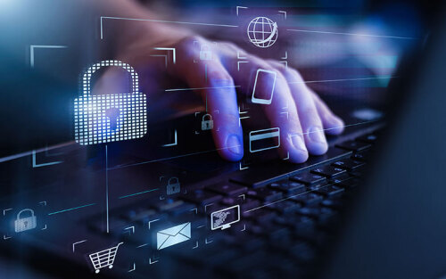 A close up of hands typing on a laptop with an overlay of security icons