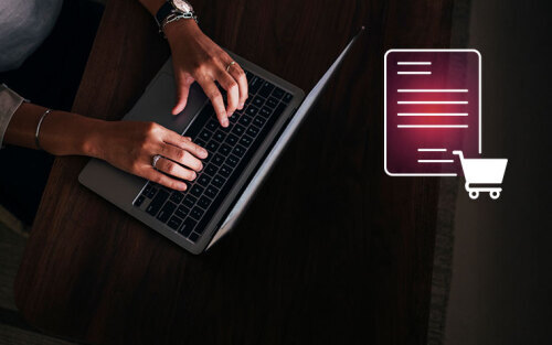 Top view of hands typing on a laptop with a PDF and shopping cart icons overlaying it