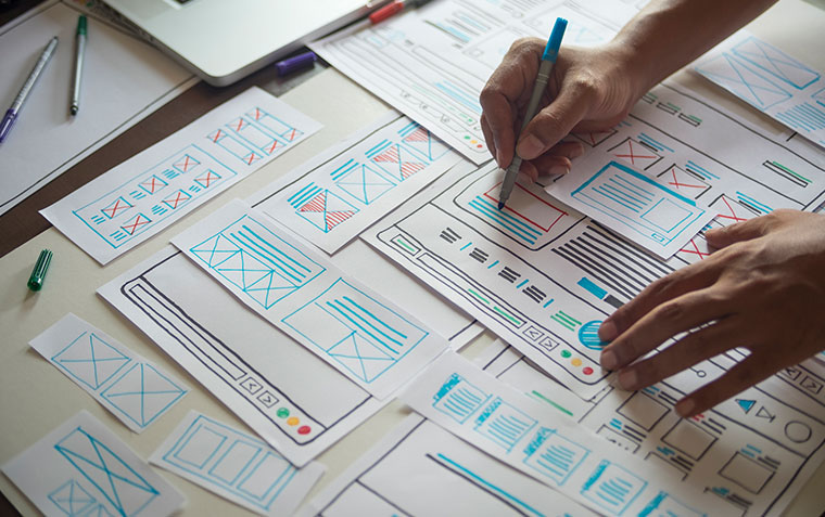 UX designer using wireframe sketches to adjust a website layout