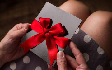 Woman opening a gift voucher in a red bow